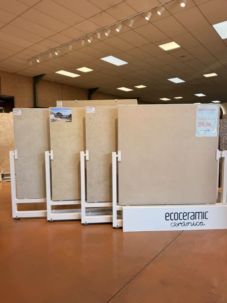 Carrelage Ecoceramic 100x100 : Promo Beige Adouci Grands carreaux de carrelage Ecoceramic beige 100x100 en promo à 29,9€ sur des présentoirs blancs.
