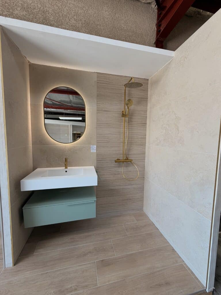 Salle de Bain Moderne : Miroir Ovale et Douche Dorée Salle de bain avec miroir ovale, meuble vert sauge et robinetterie dorée.