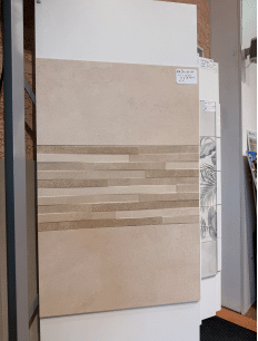 Carrelage mural beige 30x60 cm, bande centrale striée en relief. Prix affiché 22,90€.